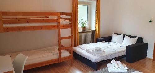 a small room with a bunk bed and a bed and a couch at Gutshof zum Wurzgarten in Hainbach