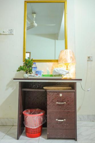 a bathroom vanity with a mirror and a basket at Hotel White House International in Dhaka