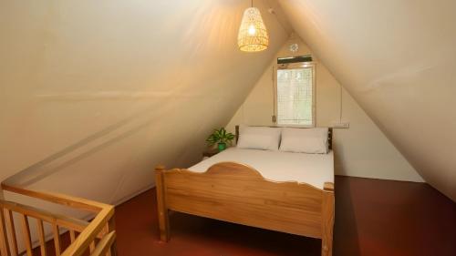 Un dormitorio pequeño con una cama y una ventana. en Tapovana - Hillside Retreat, en Thekkady