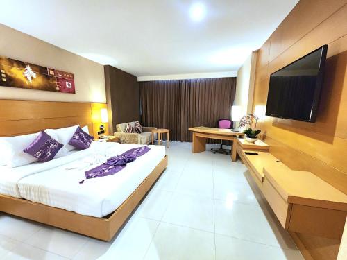 a hotel room with a bed and a flat screen tv at Masters Suites Hotel in Makkasan