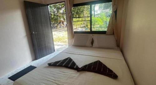 a bedroom with a bed with two pillows on it at Chomjan Hostel in Ko Phayam