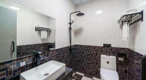 a bathroom with a toilet and a sink and a mirror at Sheng Lin Na Hotel Minzhi Branch in Shenzhen