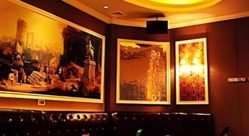 a wall with three framed pictures on a wall at Sheng Lin Na Hotel Minzhi Branch in Shenzhen