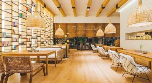 a restaurant with tables and chairs in a room at Atour Hotel Weihai Shidao in Dongshan