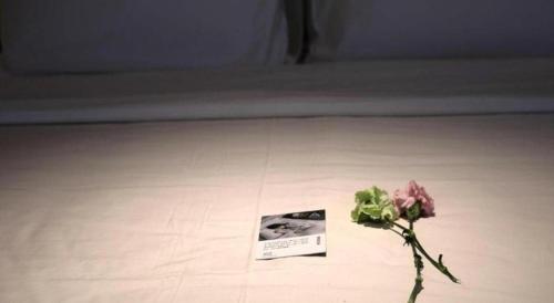 a flower in a vase next to a book at Atour Hotel Weihai Shidao in Dongshan