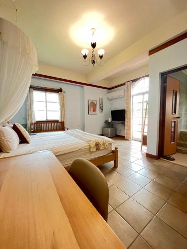 a large bedroom with a bed and a table at 墾丁亞維儂莊園民宿 in Hengchun South Gate