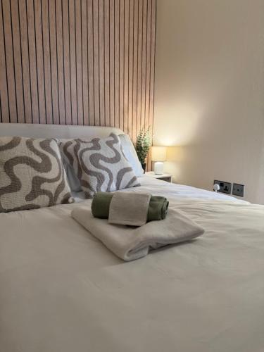 a white bed with two pillows on top of it at Basingstoke Train Station Short Stay in Basingstoke