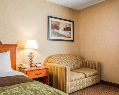 a hotel room with a chair and a bed at Quality Inn in Sidney