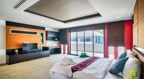 a bedroom with a large bed and a large window at Ocean Breeze Residence in Khao Lak