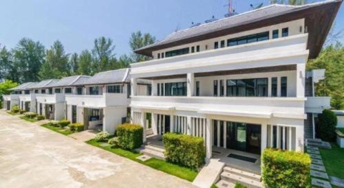 a large white building with a lot of windows at Ocean Breeze Residence in Khao Lak