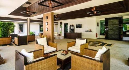 a large living room with chairs and a table at Ocean Breeze Residence in Khao Lak