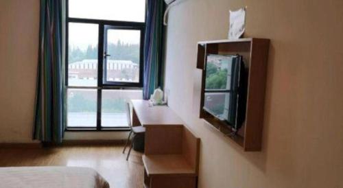 a hotel room with a bed and a tv and a window at 7 Days Inn Shanghai Minhang Dongchuan Road Jiaotong University in Shanghai