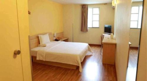 a bedroom with a bed and a desk and a television at 7 Days Inn Shanghai Minhang Dongchuan Road Jiaotong University in Shanghai