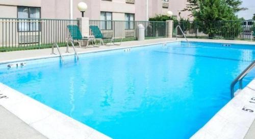 a large swimming pool with blue water in a hotel at Quality Inn Meridian in Meridian