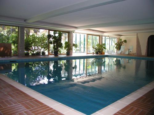 a swimming pool in a house with windows at Hotel-Pension Strolz in Mayrhofen