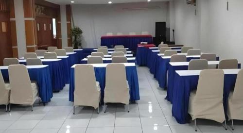 a room with blue tables and chairs in a room at Alexander Hotel Tegal in Tegal