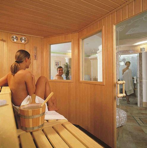 a woman sitting in a sauna looking in the mirror at Hotel-Pension Strolz in Mayrhofen