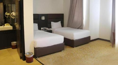 a hotel room with two beds and a mirror at The BCC Hotel & Residence in Nagoya