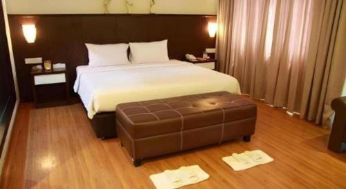 a hotel room with a bed and a ottoman at The BCC Hotel & Residence in Nagoya