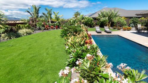 a yard with a swimming pool and green grass at ISLAND SEABATICAL Restful 3BR Ainamalu Home with Private Pool in Waikoloa
