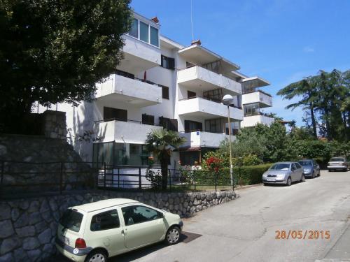 a white car parked in front of a building at Apartman Lovran in Lovran