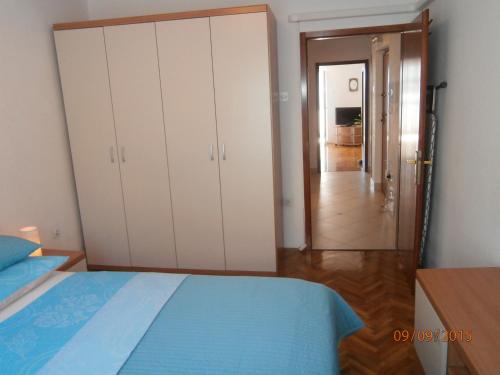 a bedroom with a bed and a closet and a hallway at Apartman Lovran in Lovran