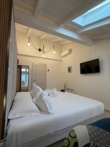 a large white bed in a room with a skylight at ROOMS,REGGIO AFFITTACAMERE con Bagno Privato, TV, Clima , Wi-Fi in Reggio Emilia