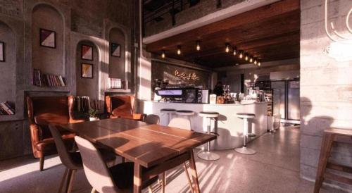 un comedor con una mesa de madera y un bar en The Singha Hotel - Korat, en Nakhon Ratchasima