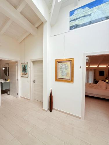 a living room with white walls and a painting on the wall at ROOMS,REGGIO AFFITTACAMERE con Bagno Privato, TV, Clima , Wi-Fi in Reggio Emilia