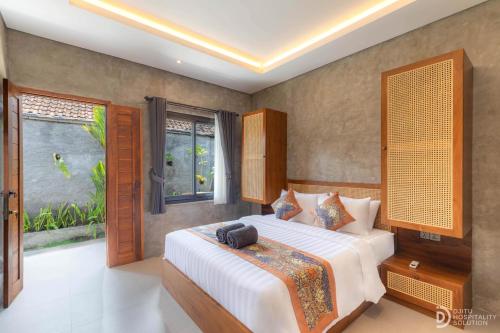 a bedroom with a large bed and a window at Anadolu Ubud in Ubud