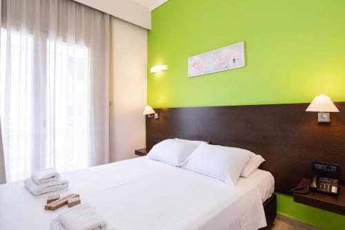a hotel room with a bed and a green wall at Sonia Hotel & Suites in Kos Town