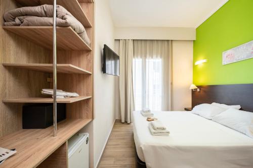 a bedroom with a bed and a green wall at Sonia Hotel & Suites in Kos Town