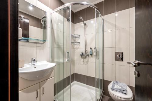 a bathroom with a shower and a sink and a toilet at Sonia Hotel & Suites in Kos Town