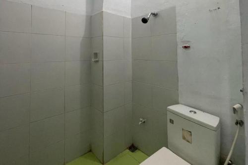Un baño blanco con ducha y WC. en Hotel O Saril Riverside HomestayNearLapangan Musara Alun, en Rawe