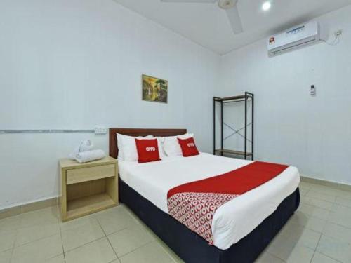 Un dormitorio con una cama grande con almohadas rojas. en Hotel O Saril Riverside HomestayNearLapangan Musara Alun, en Rawe