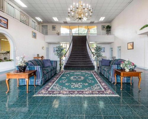 a living room with two couches and a staircase at Econo Lodge Dalton West in Dalton
