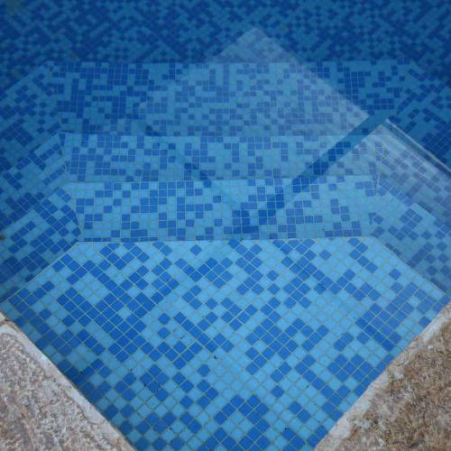 a blue tile floor in a swimming pool at פינת נופש- סויטת הרימון עם בריכה פרטית - 6 אורחים in Rosh Pinna