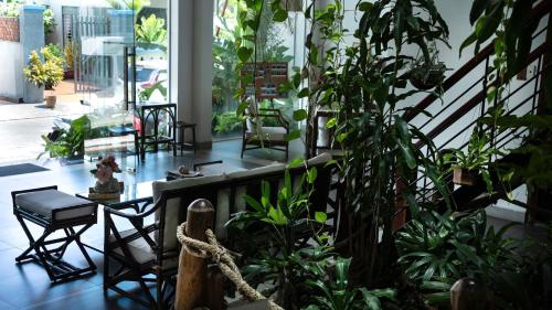 ein Zimmer voller Pflanzen und Stühle in der Unterkunft Nicobar Con Dao Hotel in Con Dao