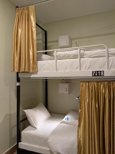 two bunk beds in a room with white beds at STAY HOSTEL - MOTORBIKE & LOCKER RENTAL Thakhek in Thakhek