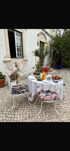 a white table and two chairs with food on it at Casa Beija flor quarto Ortencias in Mogofores