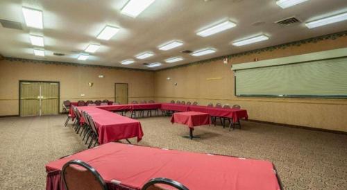 a conference room with red tables and chairs and a chalkboard at Quality Inn in Mineral Point