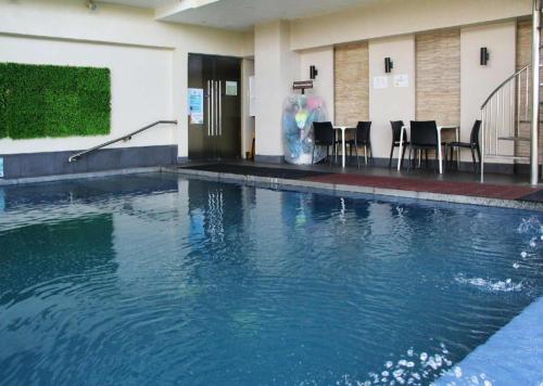 a swimming pool in a building with tables and chairs at Le Monet Hotel in Baguio