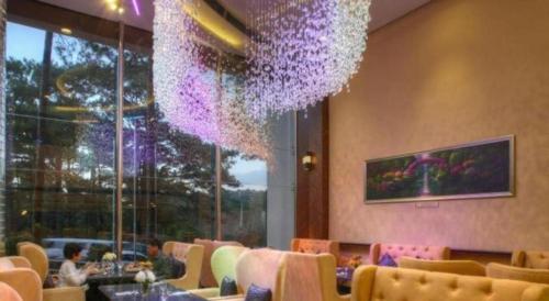 a dining room with a chandelier and tables and chairs at Le Monet Hotel in Baguio