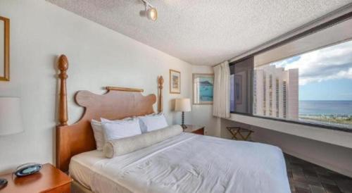 a bedroom with a large bed and a large window at Marina Tower Waikiki in Honolulu
