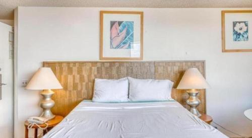 a bedroom with a large bed with two lamps at Marina Tower Waikiki in Honolulu