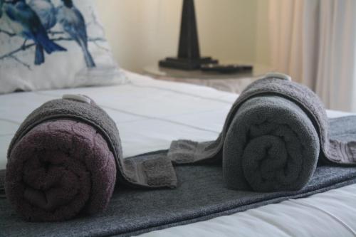 a pair of towels on top of a bed at Meander In in Howick