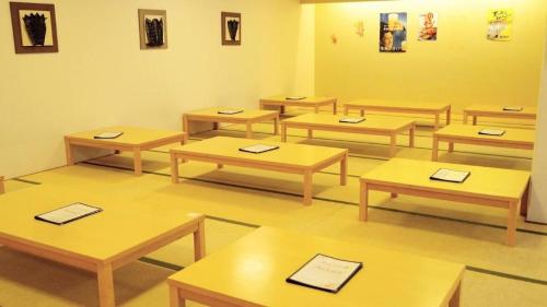 a classroom with wooden tables in a room at Ou Hotel in Yonago