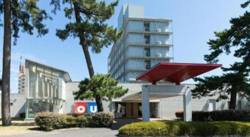 a large building with a red umbrella in front of it at Ou Hotel in Yonago