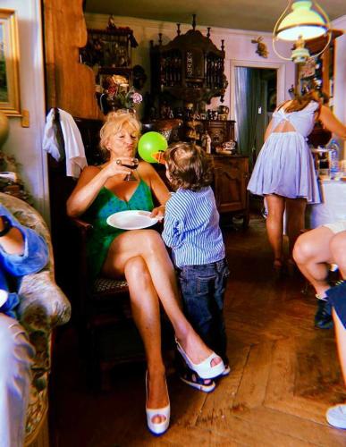 a woman sitting on a chair next to a little boy at Ballerey in Val-au-Perche
