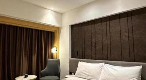 a hotel room with a bed and a chair and a window at Brits Hotel Karawang in Karawang